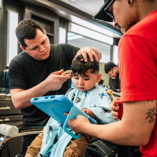 A child receiving a haircut at Don Oscar's Barbershop