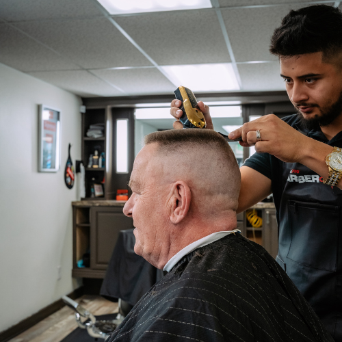 A Don Oscar's barber carefully cutting a client's hair